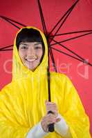 Woman in yellow raincoat holding an umbrella