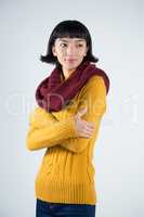 Woman in winter clothing posing against white background