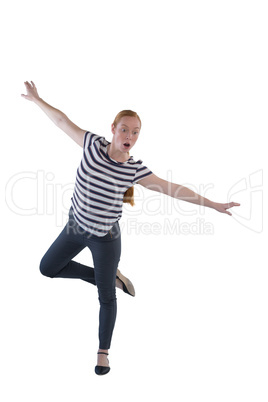 Woman balancing while walking against white background