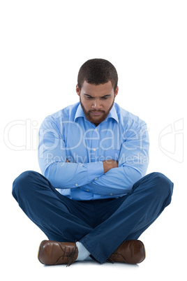 Upset male executive sitting with arms crossed