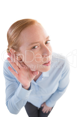 Businesswoman listening secretly with hands behind her ears