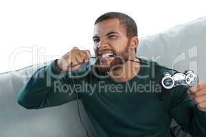Frustrated man biting a wire of joystick