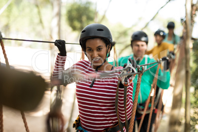 Friends enjoying zip line adventure in park