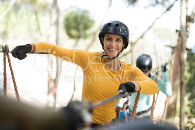 Woman enjoying zip line adventure in park