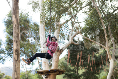 Woman enjoying zip line adventure in park