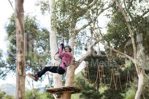 Woman enjoying zip line adventure in park