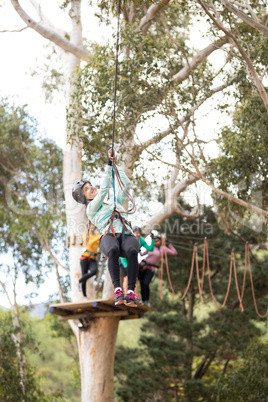 Woman enjoying zip line adventure in park