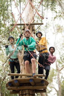 Friends getting ready to zip line in park