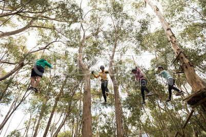 Friends enjoying zip line adventure in park