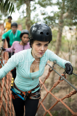 Woman walking on rope bridge