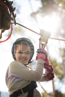 Cute girl enjoying zip line adventure on sunny day