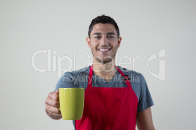 Smiling waiter offering a cup of coffee