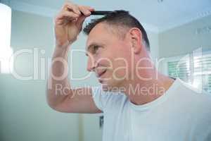 Man combing his hair in bathroom