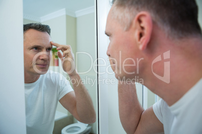 Man looking his face in the mirror