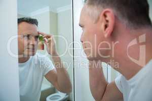 Man looking his face in the mirror