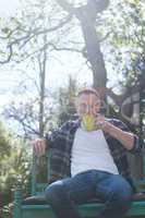 Man drinking cup of coffee in garden