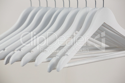 Close-up of white hangers arranged in a row