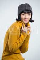 Woman in winter clothing posing against white background