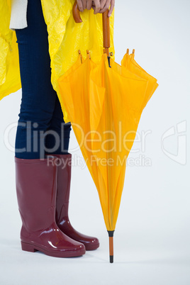 Woman in yellow raincoat holding an umbrella