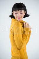 Woman in winter clothing posing against white background