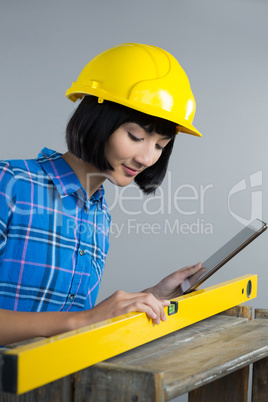 Female architect measuring plywood with engineer scale