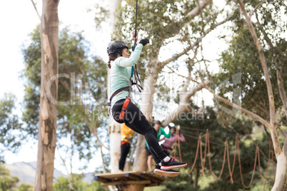 Woman enjoying zip line adventure in park