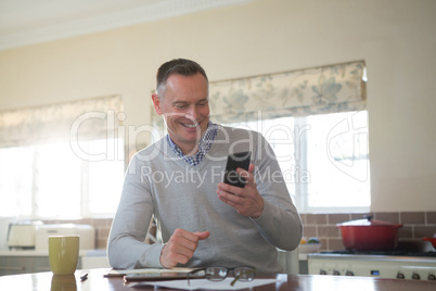 Man using mobile phone in kitchen