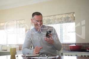 Man using mobile phone in kitchen