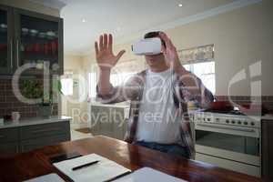 Man using virtual reality headset in kitchen