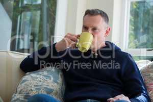 Man drinking coffee in living room