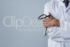 Doctor holding a stethoscope against white background