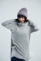 Woman in winter clothing posing against white background