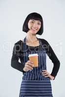 Smiling waitress serving coffee against white background