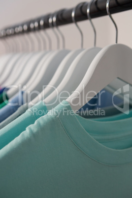 Colorful t-shirts arranged in a row on cloth rack
