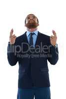 Businessman holding his finger crossed and looking upwards