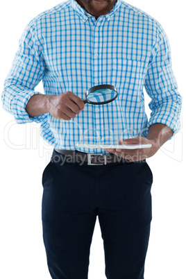 Male executive holding magnifying glass and digital tablet Male executive holding magnifying glass and digital tablet