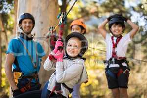 Cute girl enjoying zip line adventure on sunny day