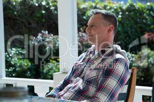 Man relaxing on chair in porch