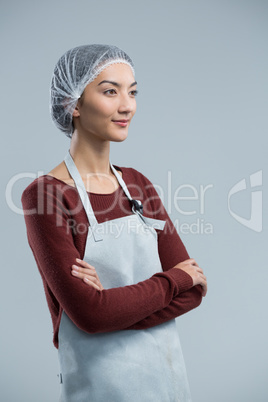 Thoughtful female chef standing with arms crossed