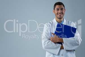 Smiling doctor standing with a file