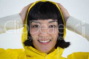 Woman wearing yellow raincoat against white background