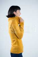 Woman in winter clothing posing against white background