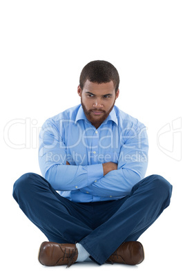 Upset male executive sitting with arms crossed