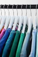 Colorful t-shirts arranged in a row on cloth rack