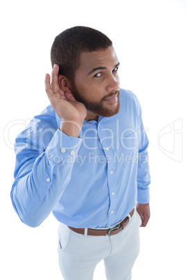 Male executive listening secretly with hands behind her ears