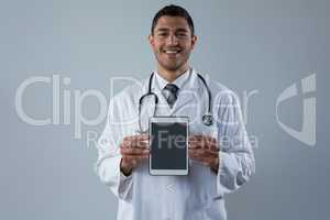 Smiling doctor holding a digital tablet