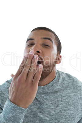 Male executive yawning against white background