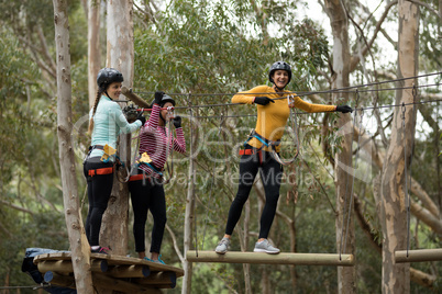 Friends enjoying zip line adventure in park