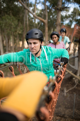 Friends walking on rope bridge