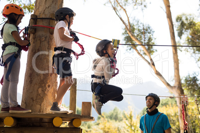 Kids enjoying zip line adventure on sunny day